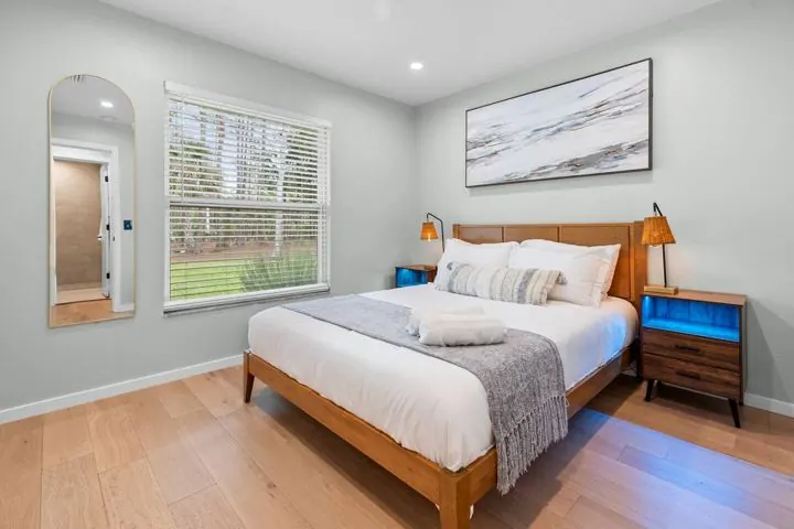 Bedroom with wood bed frame and coastal art
